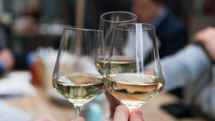 three people having a toast using three clear crystal wine glasses