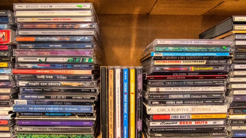 assorted cd case on brown wooden shelf