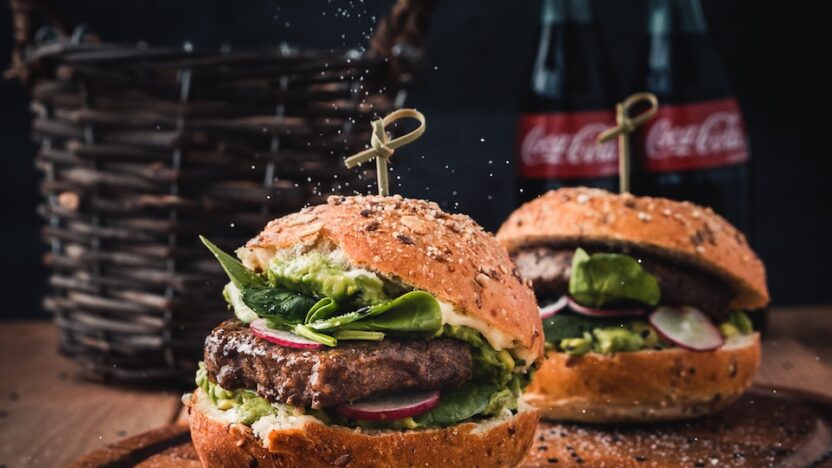 burger with vegetable on brown wooden tray