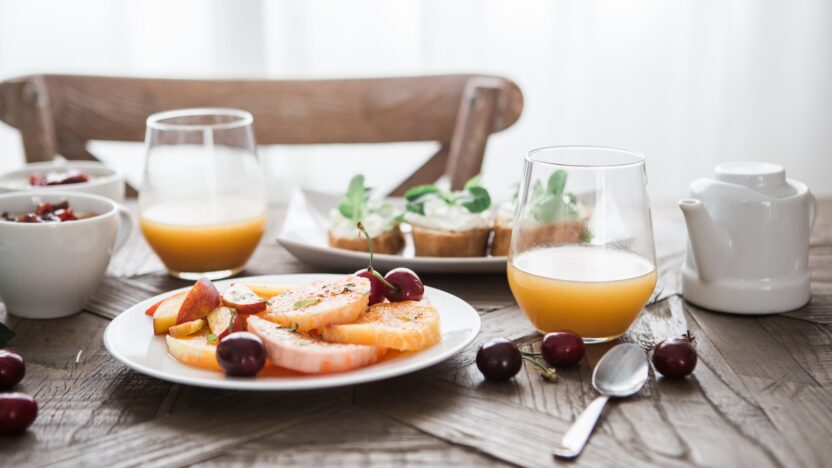 slice fruits on plate on near glass cups