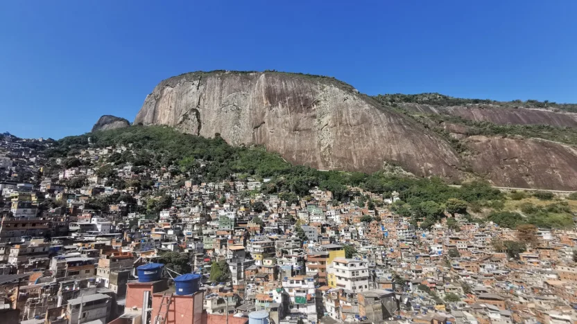 a large group of buildings in front of a rocky mountain